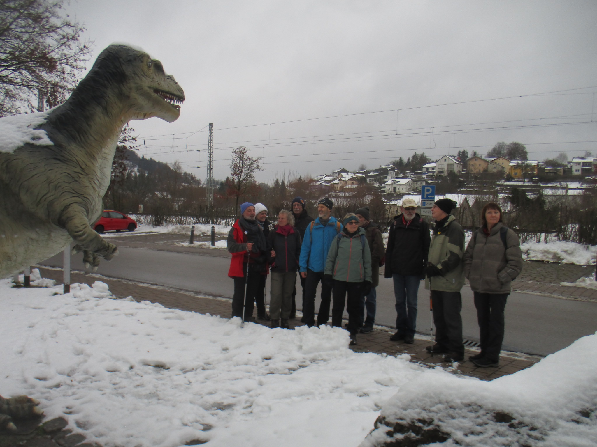 ein über vier Meter hoher Dinosaurier vor dem Solnhofer Museum. Unsere Gruppe steht daneben, ohne Angst vor dem aufgerissenen Maul des Giganten.